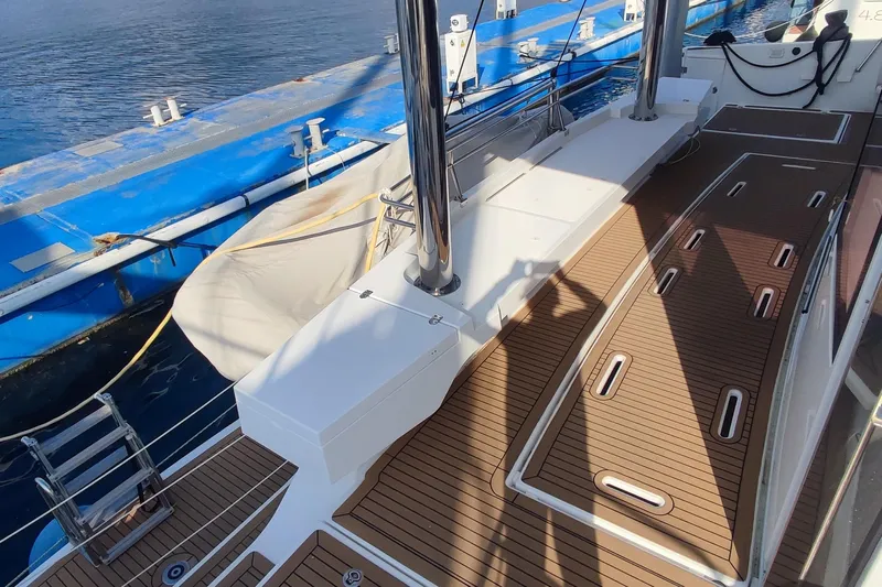 Helios Yacht Photos Pics Deck of a 2021 Bali 5.4 yacht with wooden flooring, docked by the water.