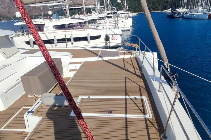 Helios Yacht Photos Pics Deck view of a 2021 Bali 5.4 yacht in a marina, surrounded by water and other boats.