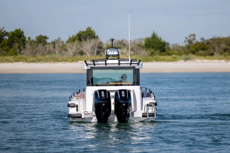  Yacht Photos Pics 2024 Axopar 28 CABIN boat with dual engines on a serene waterway.