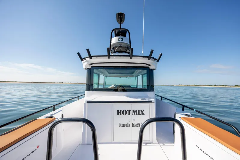  Yacht Photos Pics 2024 Axopar 28 CABIN boat on calm water, clear sky background.