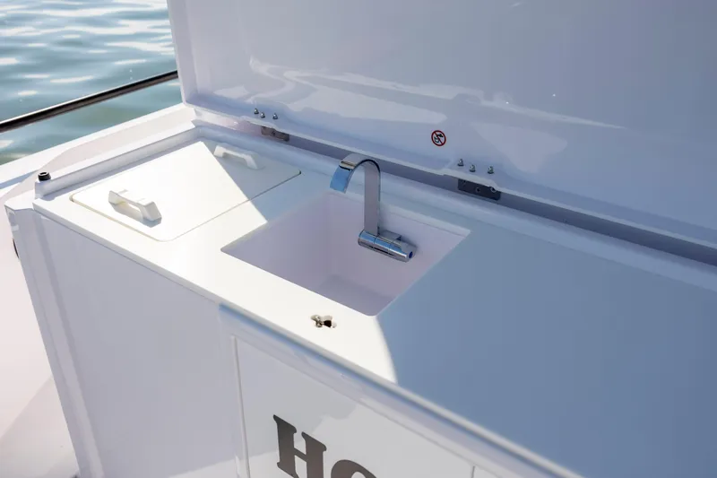  Yacht Photos Pics 2024 Axopar 28 CABIN boat sink and storage area, featuring sleek design and functionality.