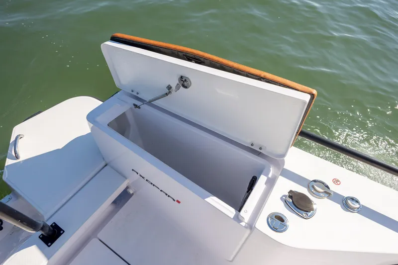  Yacht Photos Pics Open storage compartment on 2024 Axopar 28 CABIN boat, with water in the background.