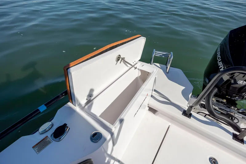  Yacht Photos Pics 2024 Axopar 28 CABIN boat with open storage compartment and outboard motor on water.