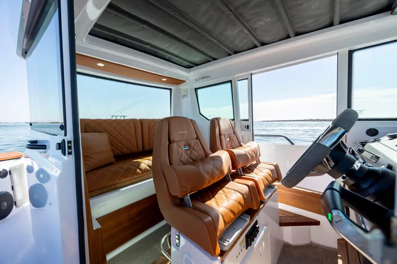  Yacht Photos Pics 2024 Axopar 28 CABIN interior with luxurious brown seating and panoramic windows.