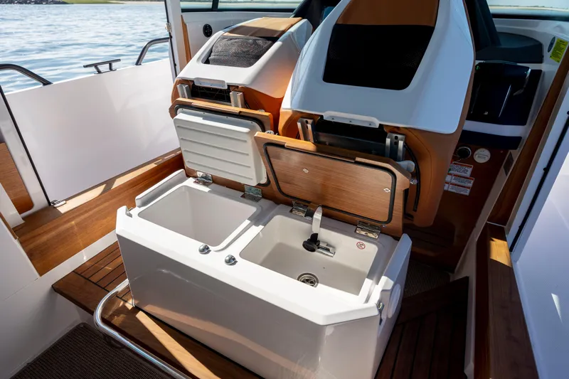  Yacht Photos Pics 2024 Axopar 28 CABIN interior with open storage compartments and sink.