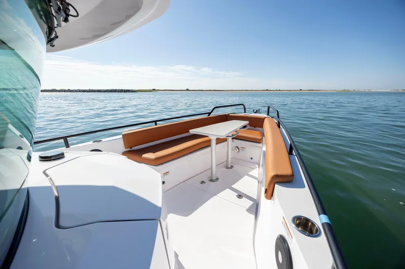  Yacht Photos Pics 2024 Axopar 28 CABIN boat with seating area and table on calm water.