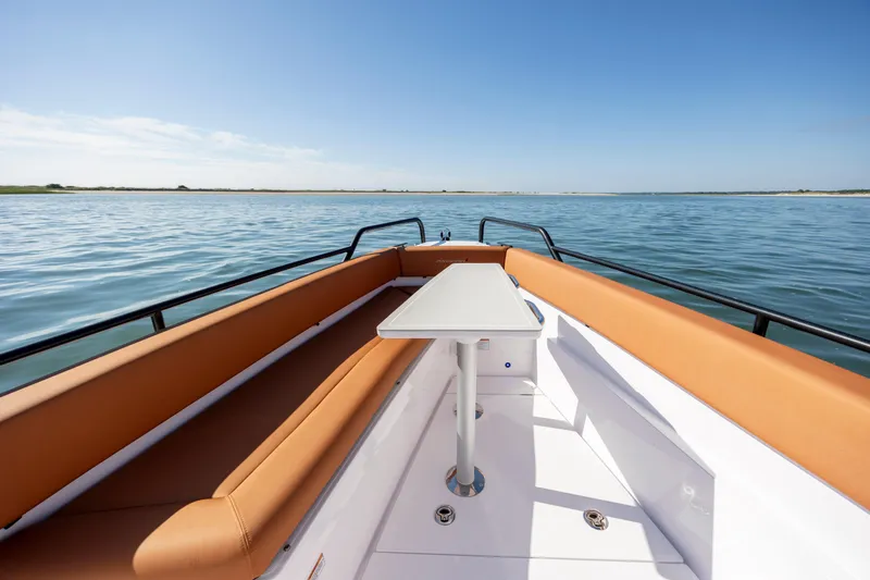  Yacht Photos Pics 2024 Axopar 28 CABIN boat with tan seating and table on calm water.