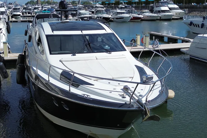  Yacht Photos Pics 2009 Marquis 500 Sport Coupe yacht docked in a marina, surrounded by other boats.