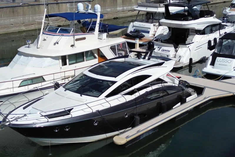  Yacht Photos Pics 2009 Marquis 500 Sport Coupe yacht docked among other luxury boats in a marina.