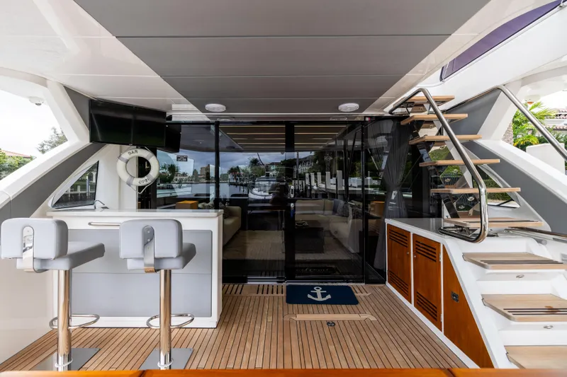 Journey Yacht Photos Pics Luxurious 2019 Sunseeker 76 yacht interior with bar, seating, and modern staircase.
