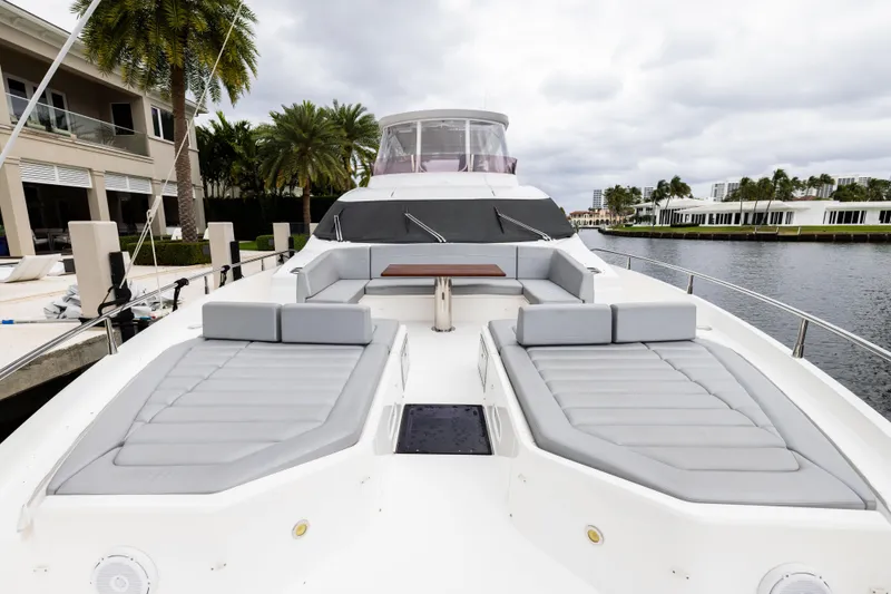 Journey Yacht Photos Pics Luxurious 2019 Sunseeker 76 yacht with spacious deck and seating area, docked by waterfront.