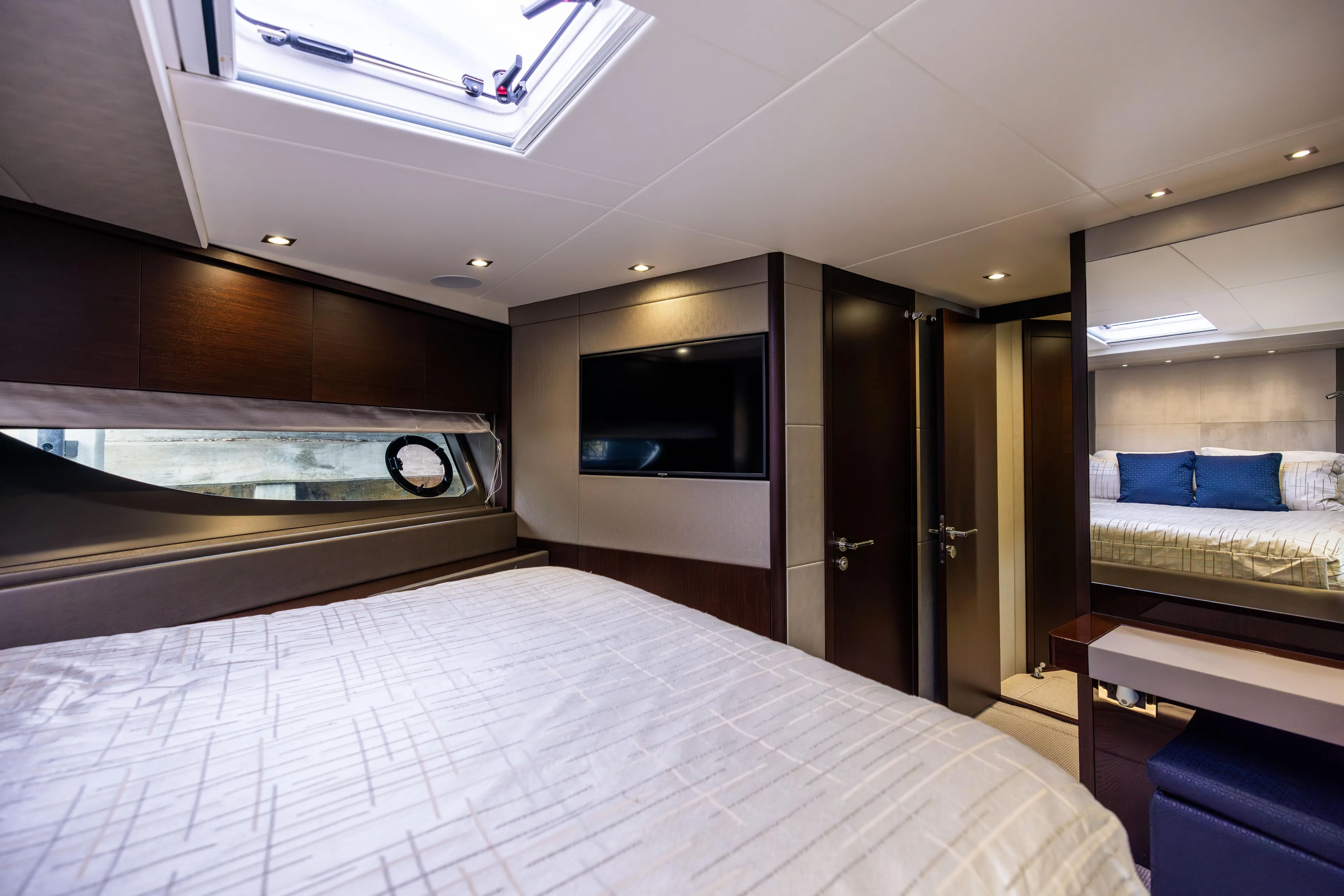 Journey Yacht Photos Pics Luxurious interior of 2019 Sunseeker 76 yacht bedroom with modern decor and skylight.