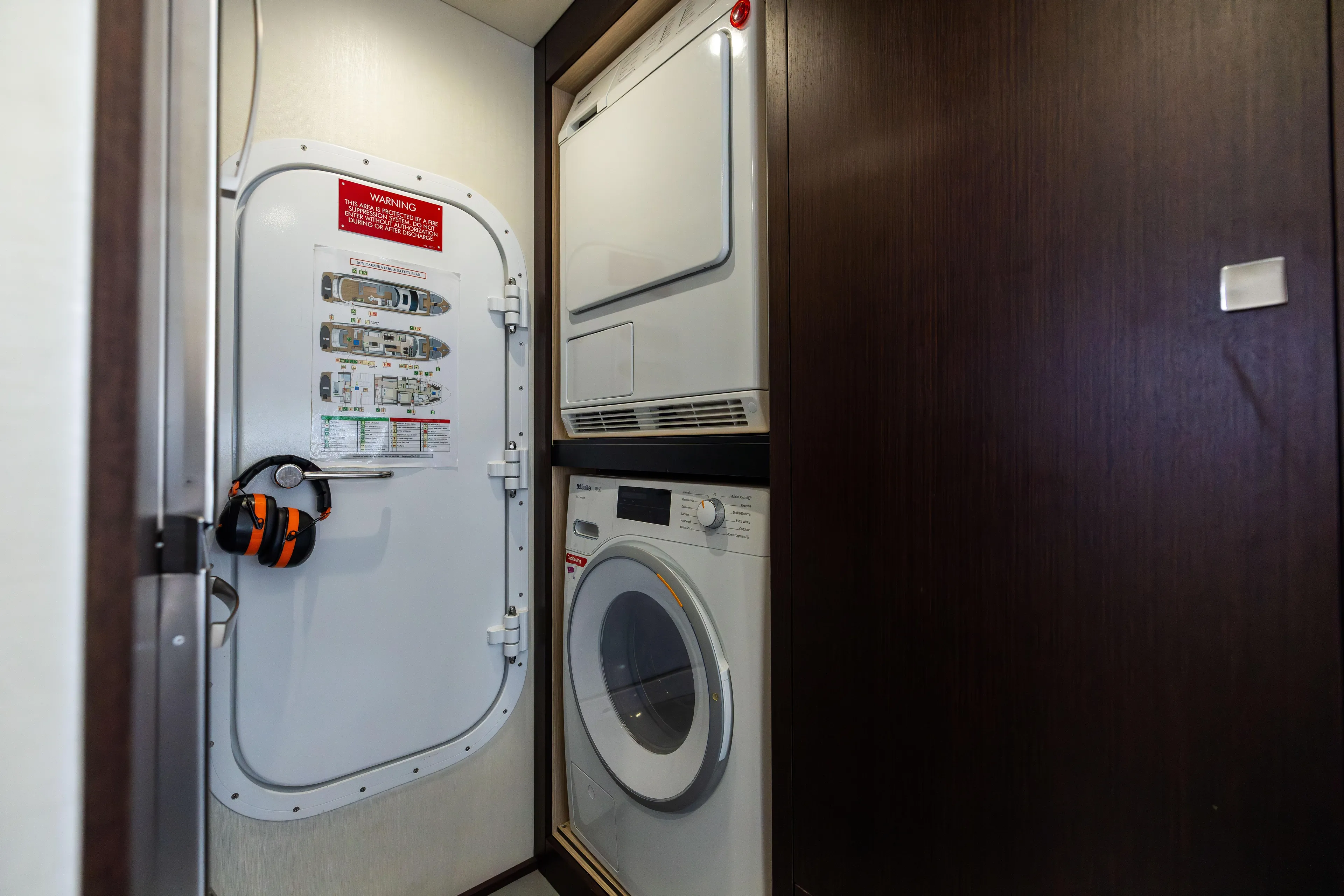 Journey Yacht Photos Pics Laundry area on 2019 Sunseeker 76 yacht with washer, dryer, and safety door.