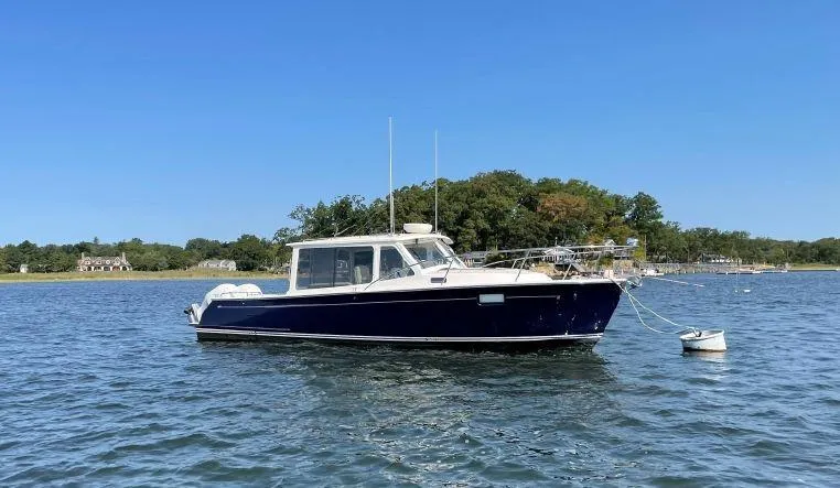 Corsair Yacht Photos Pics 2020 MJM 35z boat anchored on calm water with trees in the background.