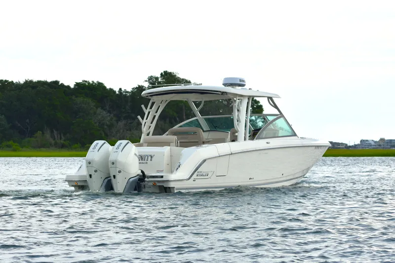  Yacht Photos Pics 2023 Boston Whaler 320 Vantage boat cruising on a serene waterway.