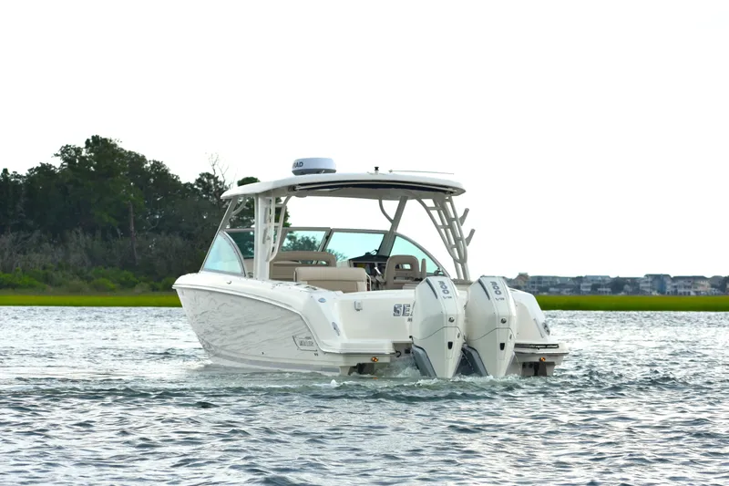  Yacht Photos Pics 2023 Boston Whaler 320 Vantage boat cruising on a calm waterway.