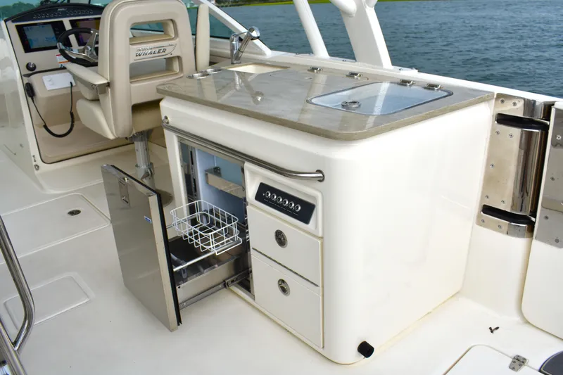  Yacht Photos Pics 2023 Boston Whaler 320 Vantage boat interior with open fridge and control panel.