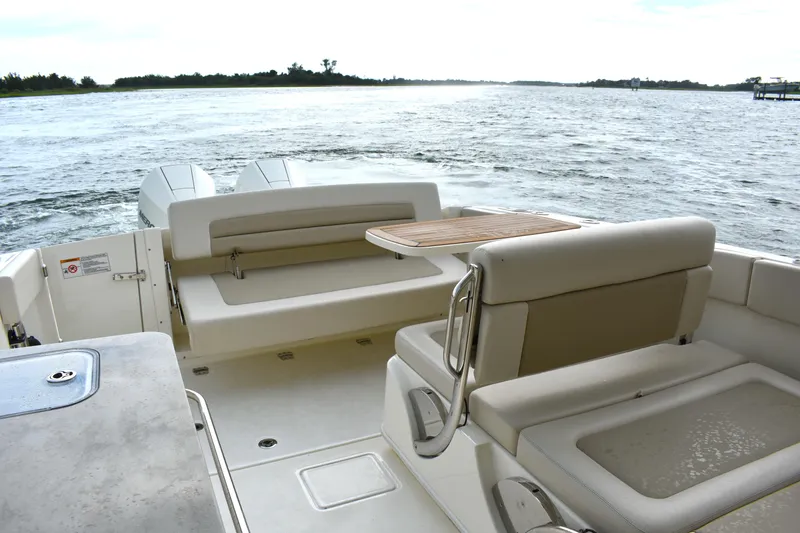  Yacht Photos Pics 2023 Boston Whaler 320 Vantage boat interior with seating and table on open water.