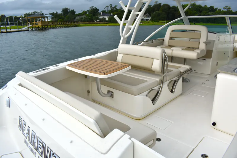  Yacht Photos Pics 2023 Boston Whaler 320 Vantage boat interior with seating and table on the water.