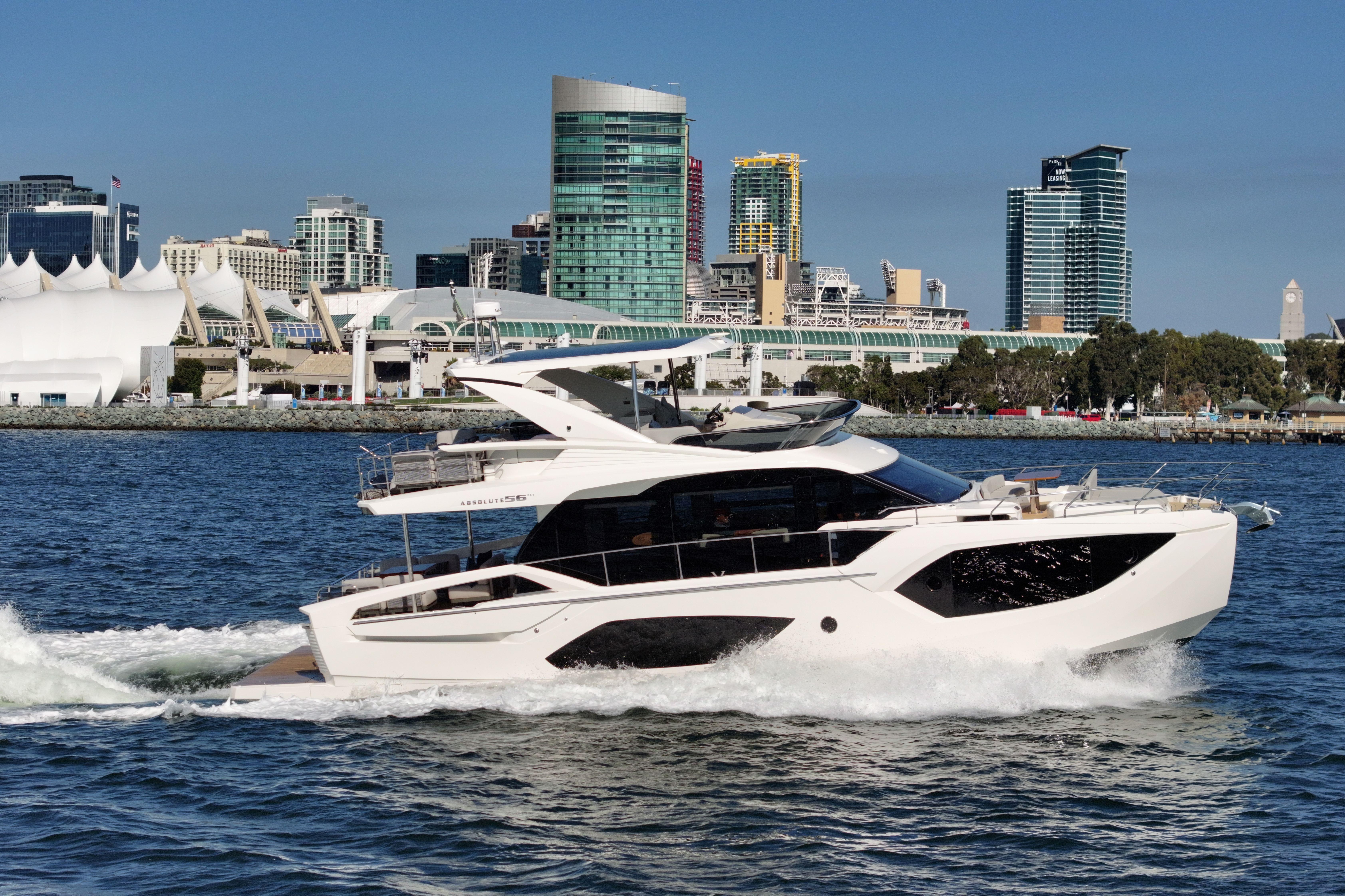 2025 Absolute 56 FLY yacht cruising near city skyline on a sunny day.