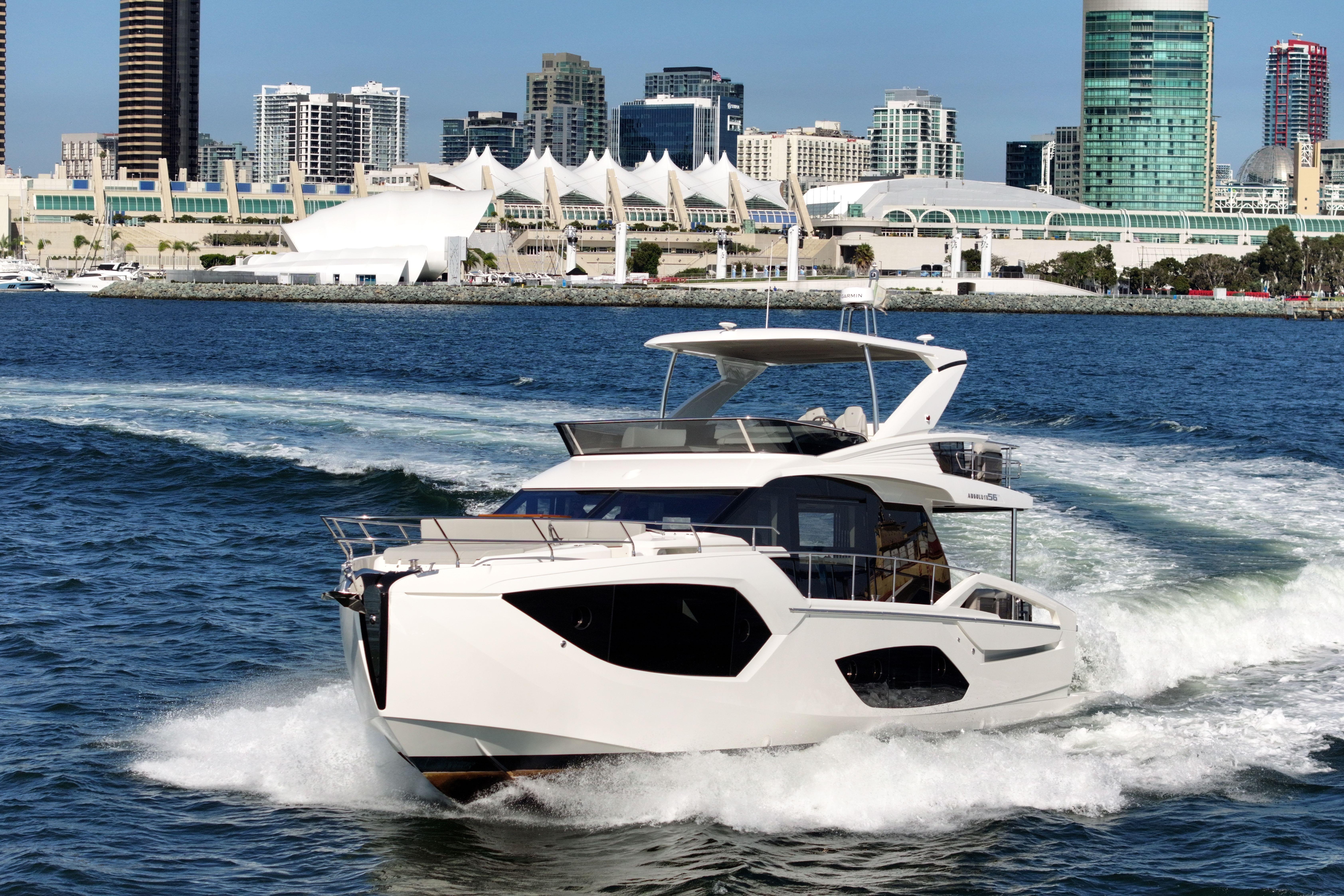 Luxury 2025 Absolute 56 FLY yacht cruising near urban skyline.