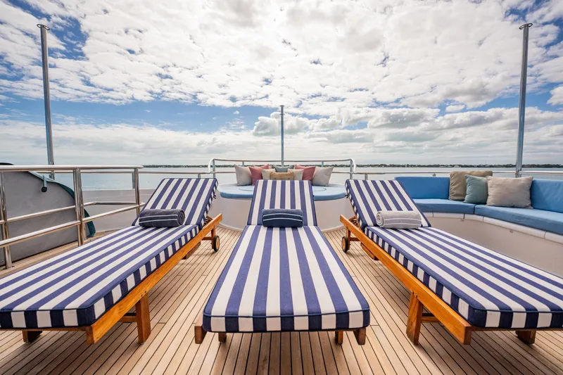 Island Heiress Yacht Photos Pics Luxurious deck of 1996 Cheoy Lee 145 Global Series yacht with striped loungers.