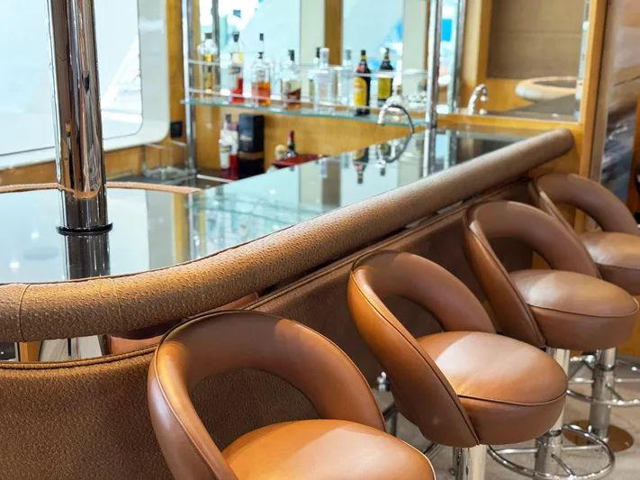 Island Heiress Yacht Photos Pics Luxurious yacht bar with leather stools, mirrored shelves, and assorted bottles on Cheoy Lee 145 Global Series.