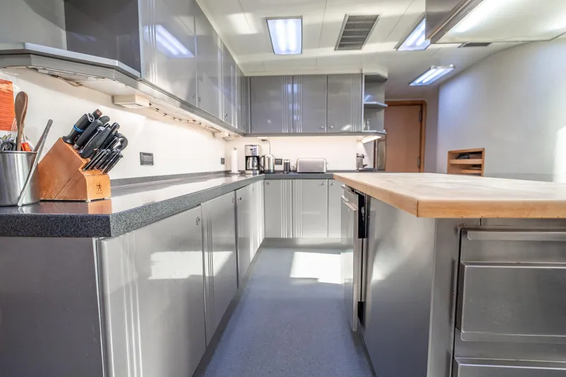 Island Heiress Yacht Photos Pics Modern kitchen interior on 1996 Cheoy Lee 145 Global Series yacht, featuring sleek cabinetry and countertops.