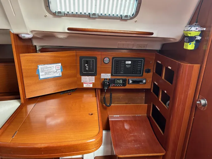 Flaneuse Yacht Photos Pics 2003 Beneteau 36.7 yacht interior navigation station with wood finish and control panels.