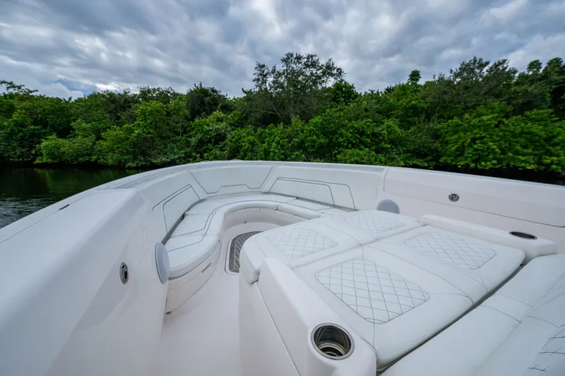 Mrs Diagnosis Yacht Photos Pics Luxurious seating on 2020 Intrepid 407 Panacea boat, surrounded by lush greenery.
