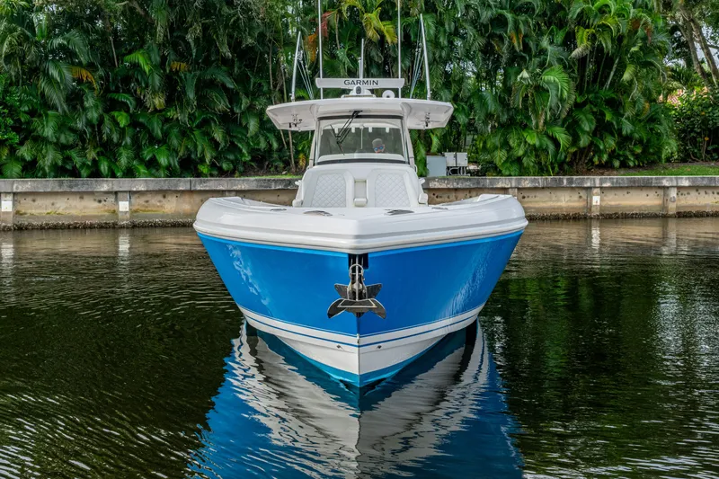 Mrs Diagnosis Yacht Photos Pics 2020 Intrepid 407 Panacea boat on calm water, surrounded by lush greenery.