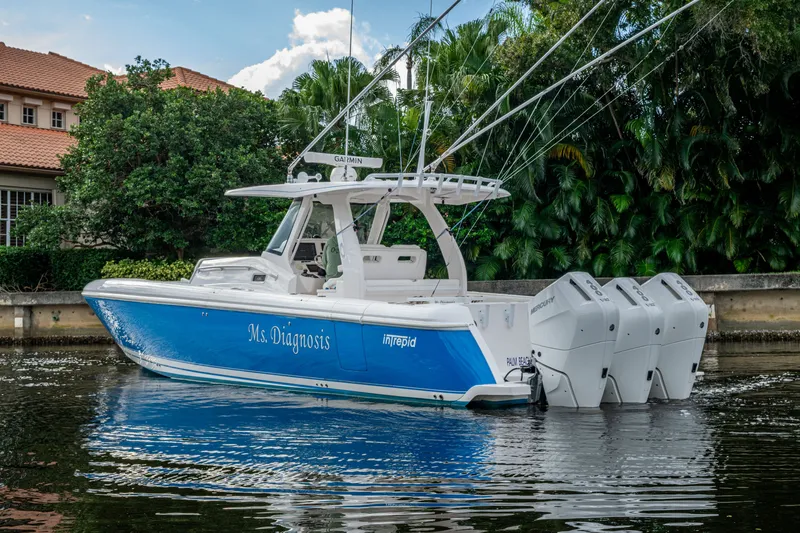Mrs Diagnosis Yacht Photos Pics 2020 Intrepid 407 Panacea boat with triple Mercury engines on a calm waterway.