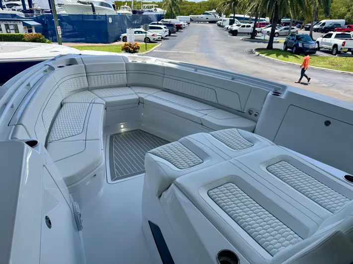  Yacht Photos Pics Luxurious seating area on 2025 Intrepid 41 Panacea boat, docked with palm trees in background.