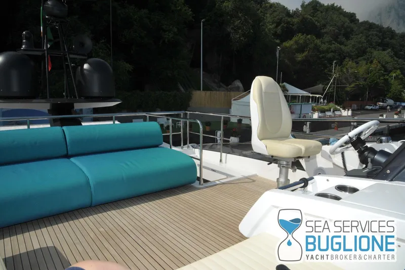 Elisa II Yacht Photos Pics 2018 Azimut 77 S yacht deck with seating and controls, docked near lush greenery.