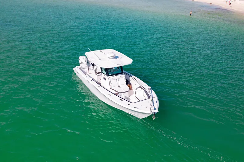  Yacht Photos Pics 2022 Crevalle 33 CSF boat on clear turquoise water near sandy beach.