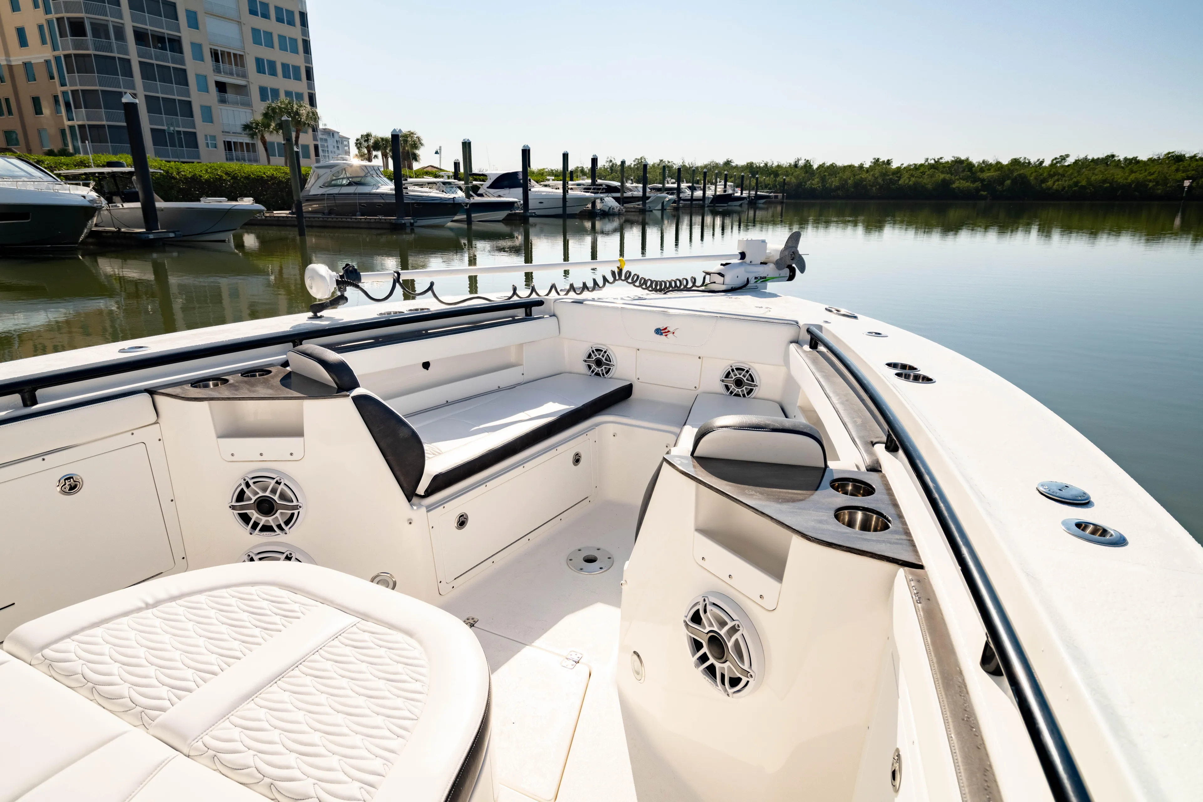  Yacht Photos Pics 2022 Crevalle 33 CSF boat interior with seating, speakers, and cup holders in a marina setting.