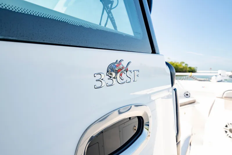  Yacht Photos Pics 2022 Crevalle 33 CSF boat detail with logo, docked under clear blue sky.