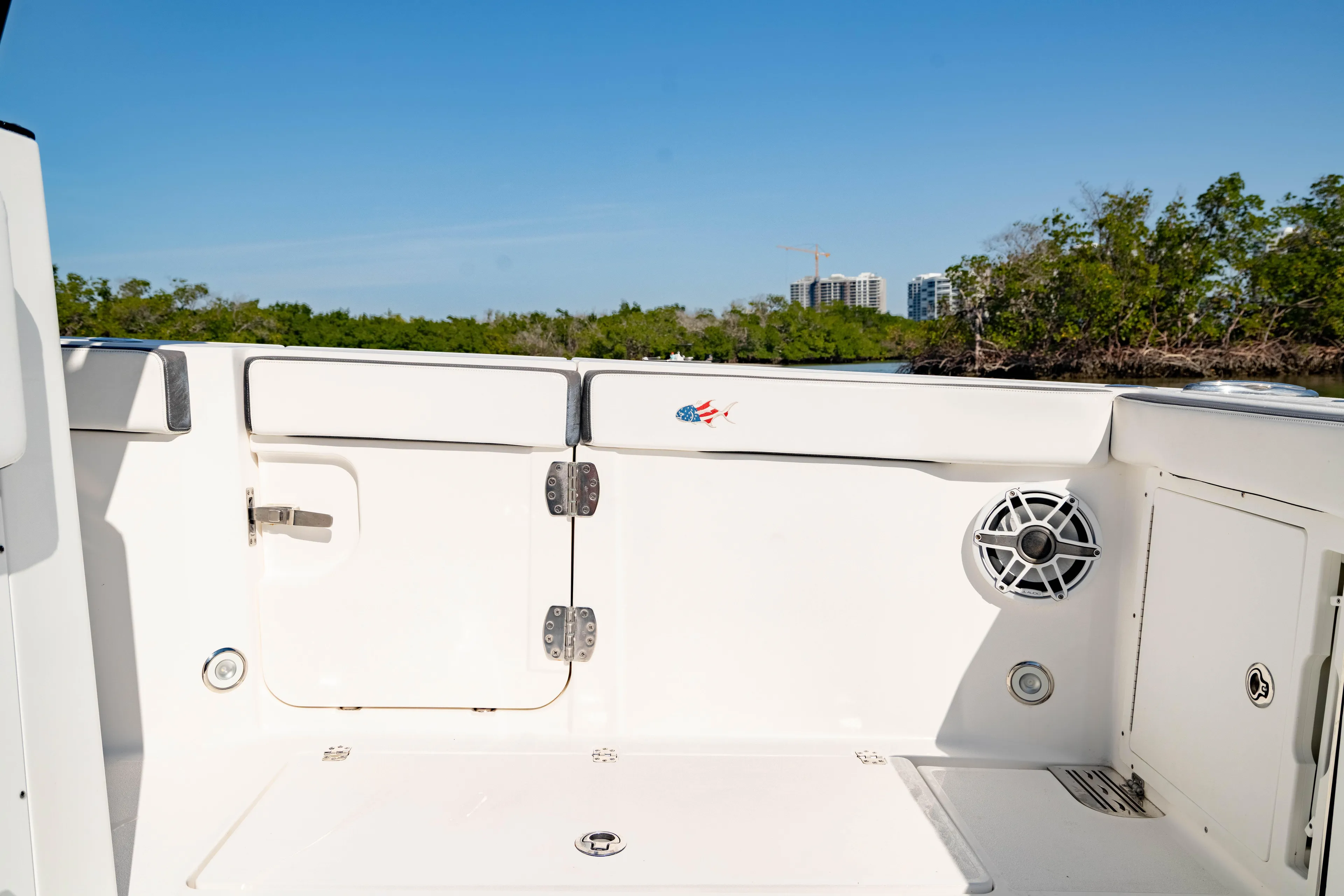  Yacht Photos Pics 2022 Crevalle 33 CSF boat interior with speaker and storage, surrounded by lush greenery.