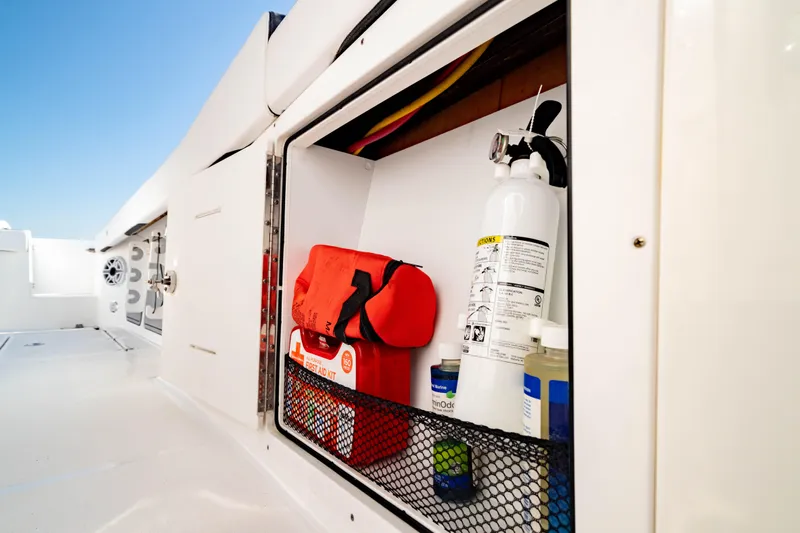  Yacht Photos Pics Storage compartment on 2022 Crevalle 33 CSF boat with safety equipment and first aid kit.