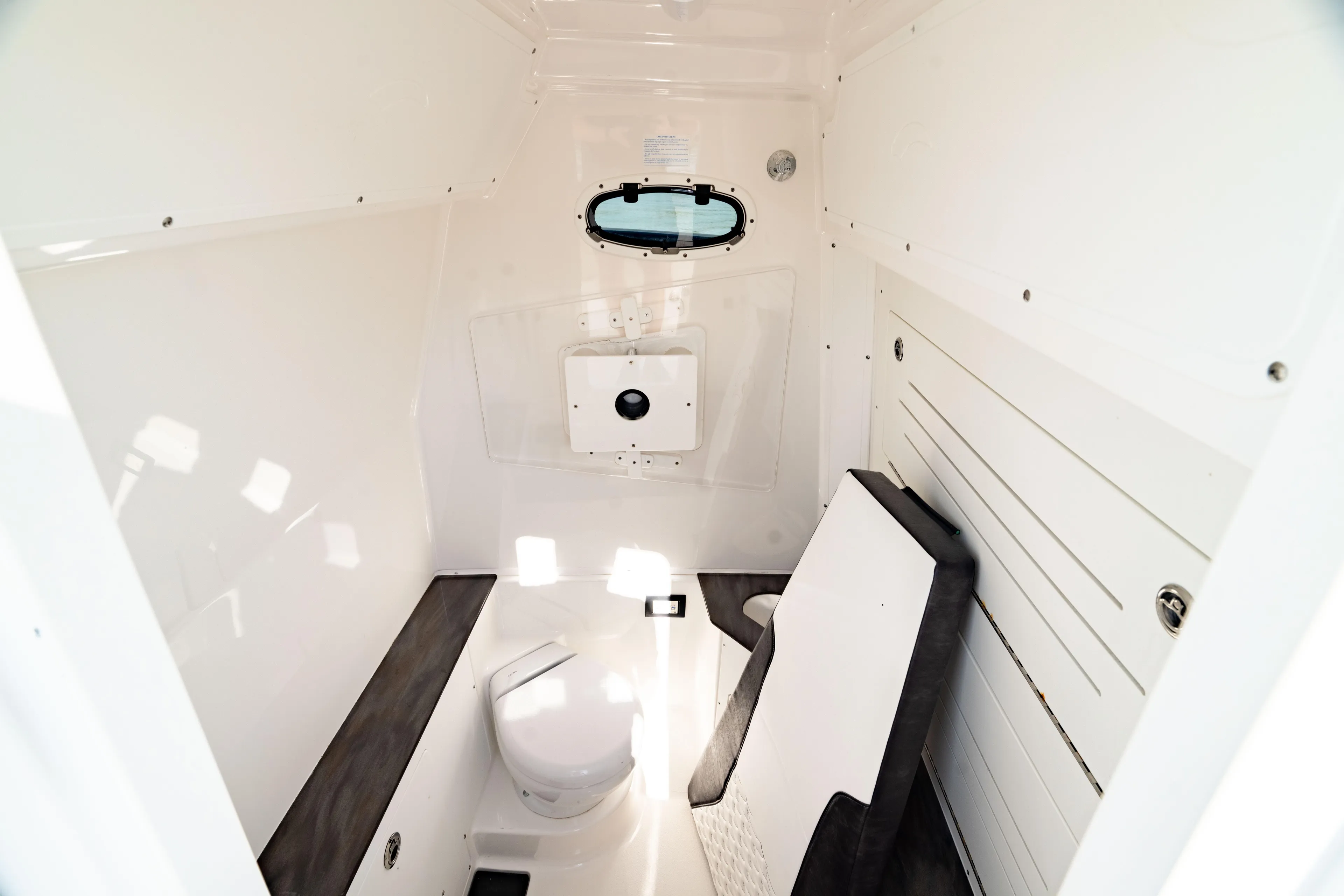  Yacht Photos Pics 2022 Crevalle 33 CSF boat interior cabin with compact toilet and seating.