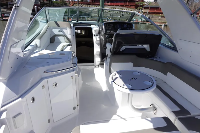  Yacht Photos Pics 2018 Monterey 295 Sport Yacht interior with seating, table, and helm, docked at marina.