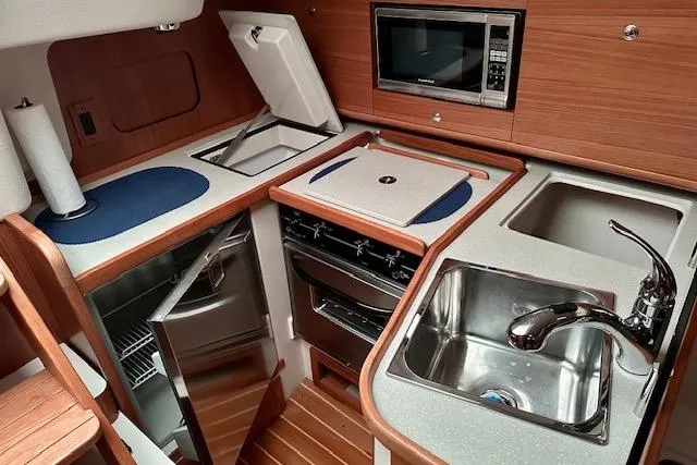 Yacht Photos Pics 2015 Catalina 315 yacht kitchen with sink, stove, microwave, and refrigerator.