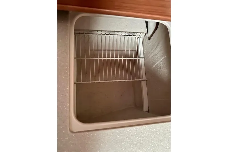  Yacht Photos Pics Empty storage compartment with wire rack inside a 2015 Catalina 315 boat.