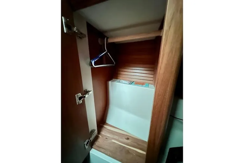  Yacht Photos Pics Wooden closet interior in a 2015 Catalina 315 sailboat, featuring hangers and storage space.