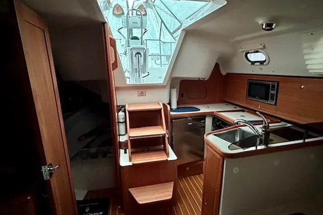  Yacht Photos Pics Interior of 2015 Catalina 315 sailboat with modern kitchen and wooden finishes.