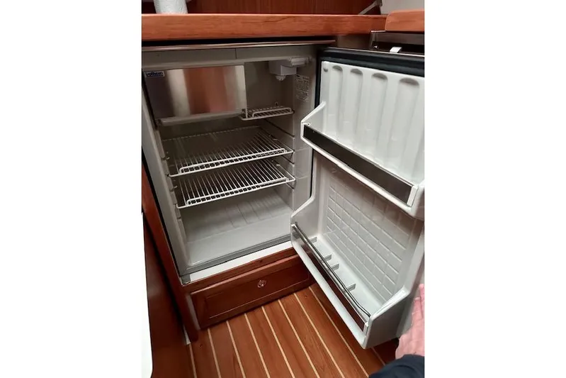  Yacht Photos Pics Open refrigerator inside a 2015 Catalina 315 yacht, featuring wire shelves and door storage.