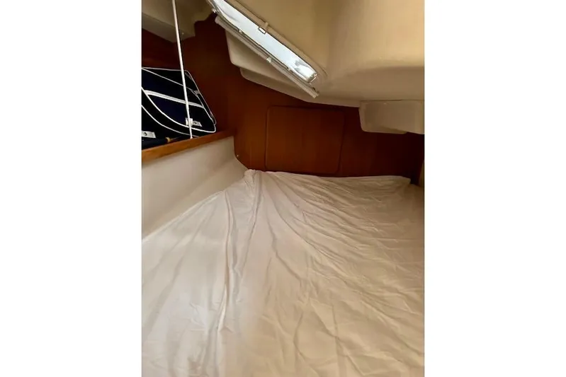  Yacht Photos Pics Interior cabin of 2015 Catalina 315 sailboat with white bedding and wooden accents.