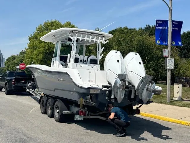  Yacht Photos Pics 2025 Crevalle 33 CTF boat on trailer, parked on street with trees in background.