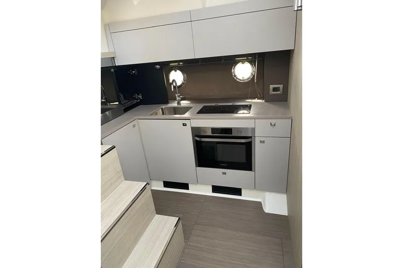  Yacht Photos Pics Modern kitchen interior of 2020 Cranchi M 44 HT yacht with sleek cabinetry and appliances.
