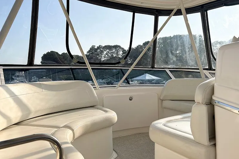  Yacht Photos Pics Interior of 2002 Silverton 42 Convertible yacht with white seating and panoramic windows.